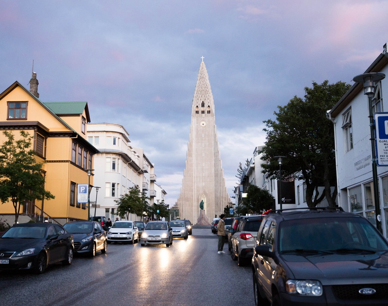 motor vehicle, street, cloud - sky, mode of transportation, plant, nature, road, reykjavik, building, city, tree, 4K, sky, hallgrimskirkja, architecture