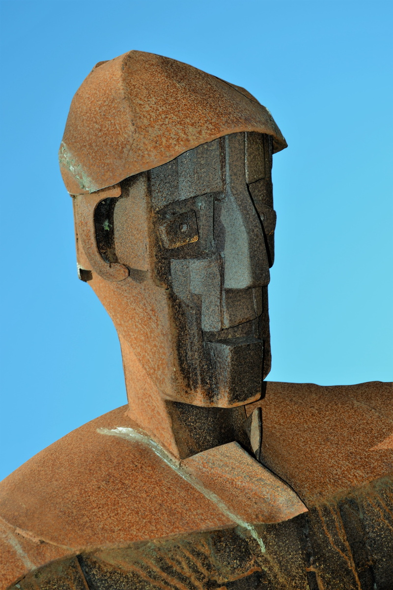 clear sky, face, outdoors, Metal, sky, portrait, stone, fire, tattoo, iron, Iron, solid, eyes, relief, representation, low angle view, statue, blue, Man