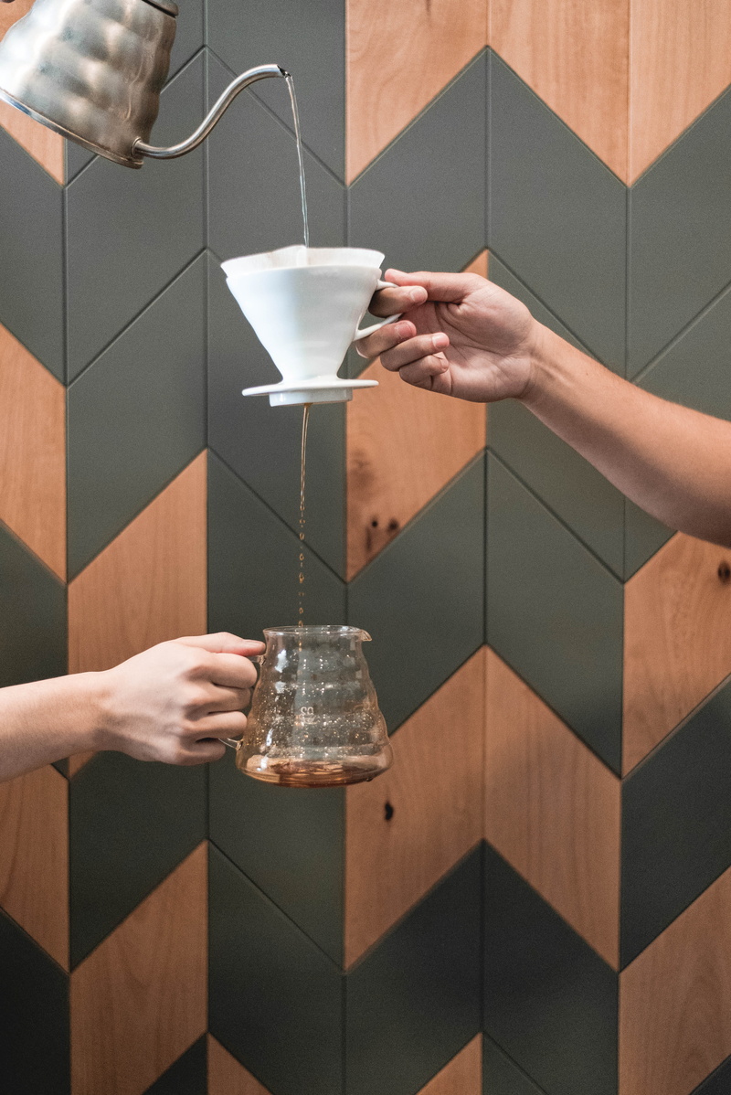 leisure activity, human body part, mug, food and drink, drink, indoors, container, people, midsection, coffee shop, pouring, pour over, lifestyles, holding