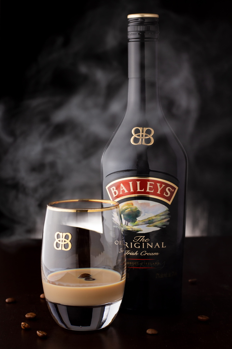 smoke, still life, freshness, indoors, glass, text, no people, black background, food and drink, household equipment, container, irish cream, table, drinking glass