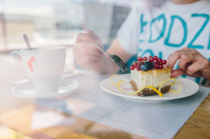 cheese, woman, indoor, cheese cake, food, human body part, table, sweet, cafeteria, drink, hand, meal, indoors, adult, food and drink, cafe, sitting, mug