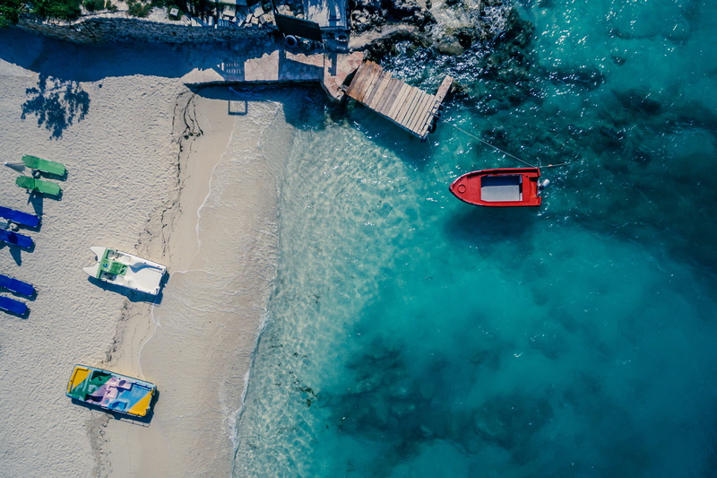 sandy beach, near, motion, view, colours, 2K, red, outdoors, brown, sea side, beach, land, board, nautical vessel, dron, sea, aerial, no people, water