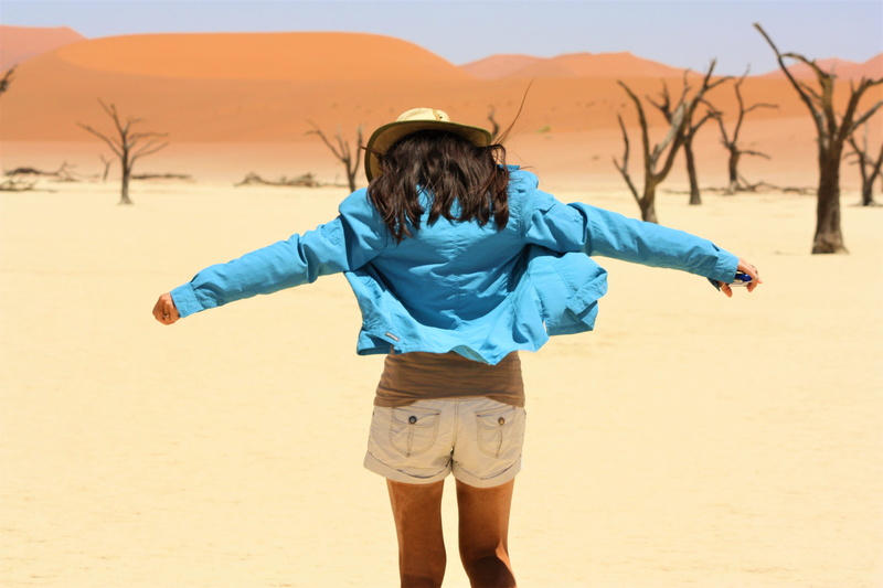 one person, deadvlei, casual clothing, dry, blue, full length, africa, leisure activity, wind, sky, land, sand, rear view, nature, desert, hairstyle, arms