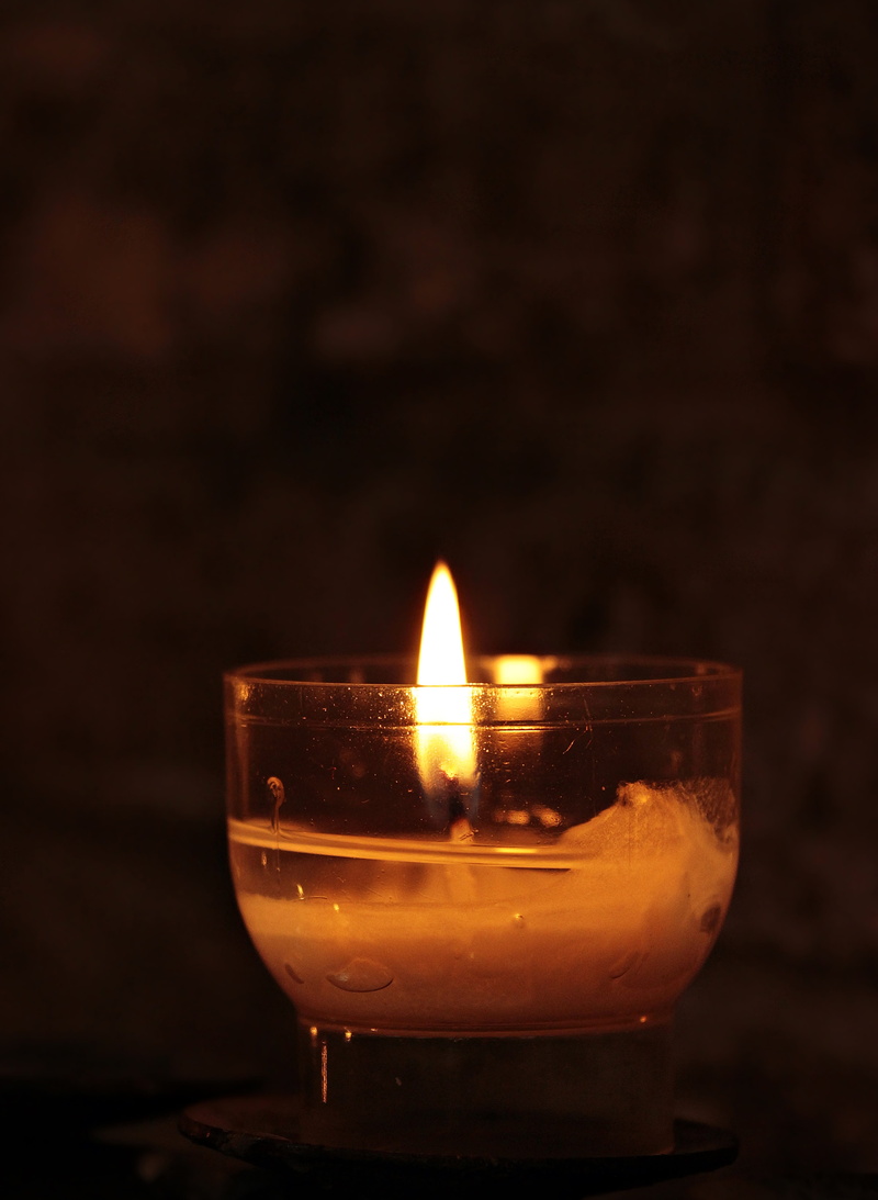fire, black background, tealight, illuminated, religion, luminosity, indoors, flame, prayer, reflection, christianity, heat - temperature, symbol, lighting equipment