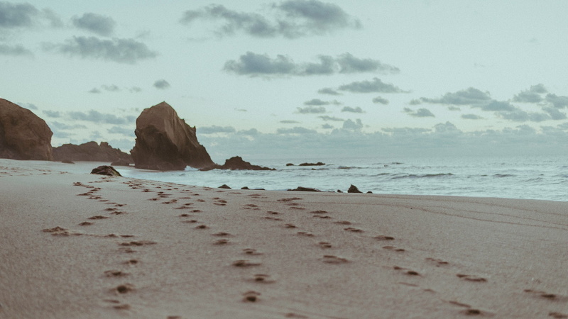 no people, solid, footprints, nature, cloud - sky, tranquility, beauty in nature, coastline, grey, water, sand, scenics - nature, motion, beach, rock - object