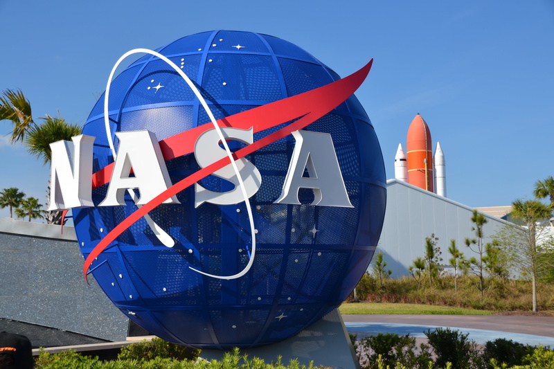 white color, transportation, mode of transportation, sky, space, statue, sunlight, built structure, plant, visitors center, space shuttle, outdoors, architecture