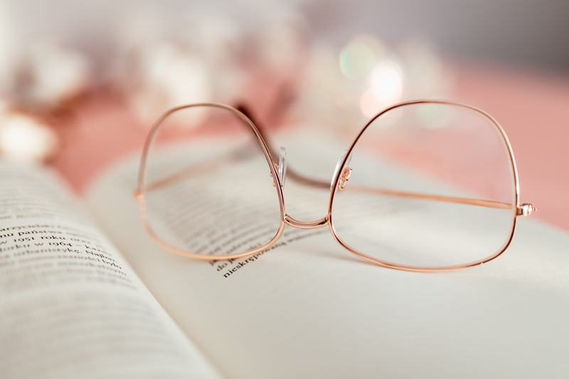 two objects, positive emotion, reading, indoors, study, open, selective focus, paper, learning, 5K, textile, clothing, personal accessory, eyeglasses