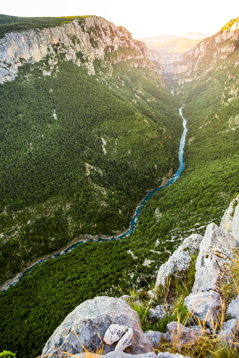 water, sunlight, non-urban scene, water courses, solid, environment, green color, plant, rock - object, tranquil scene, sky, mountain, nature, summer, tranquility