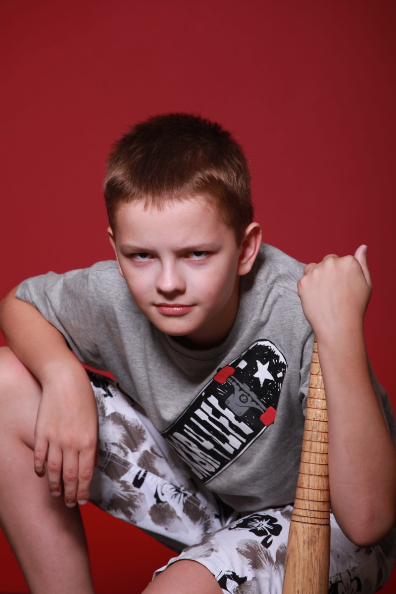 adolescence, colored background, portrait, 4K, one person, aggression, schoolboy, teenager, child, dangerous, indoors, innocence, red, holding, sitting