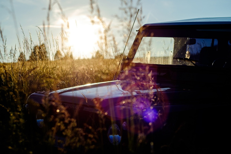 sunset, photography, mode of transportation, sky, motor vehicle, transportation, lens flare, reflection, land vehicle, trees, glass - material, car, one person