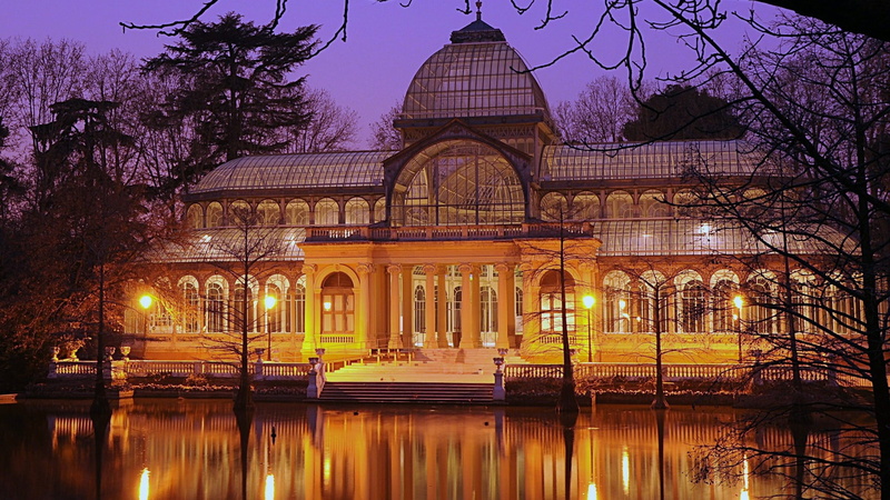arch, illuminated, incidental people, reflection, tree, retiro park, sky, travel destinations, water, building, cristal palace, spain, dusk, lighting, tourist attraction