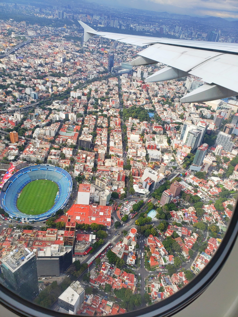airplane, community, city, buildings, built structure, intersection, no people, cityscape, building exterior, day, scenery, bullring, transportation, building