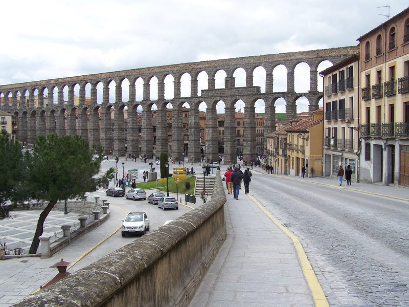 aqueduct, real people, building exterior, travel, azoguejo, land vehicle, cloud - sky, people, road, 2K, monument, arch, incidental people, architecture