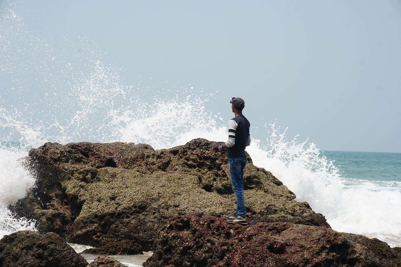leisure activity, beauty in nature, looking at view, power in nature, seawave, alone guy, seashore, full length, guy, rock - object, real people, lifestyles