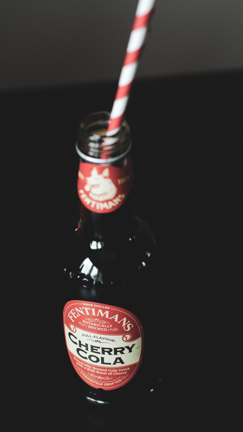 table, food and drink, straw, red, focus on foreground, 2K, bottle, text, studio shot, high angle view, container, no people, close-up, still life, drink