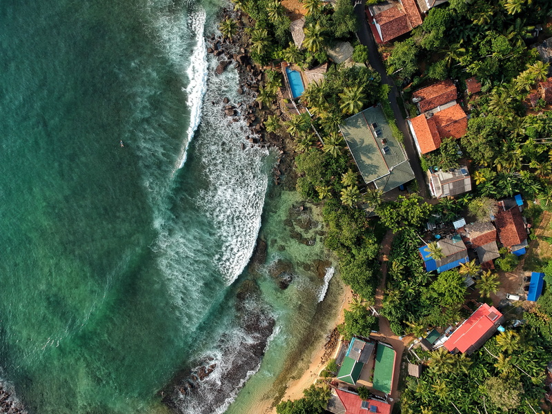 built structure, tree, building exterior, surfing, beauty in nature, water, day, beach, mirissa, high angle view, ocean, no people, nature, aquatic sport