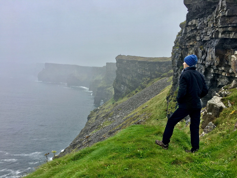 beauty in nature, sky, cliffs of moher, mountains, misty, moody, outdoors, one person, mountain, sheer, tranquil scene, full length, burren way, leisure activity