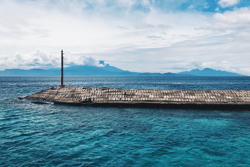 promontory, shoreline, groyne, solid, coast, land, white, kecamatan klungkung, beauty in nature, day, dock, cloud - sky, port, building, idyllic, tranquil scene