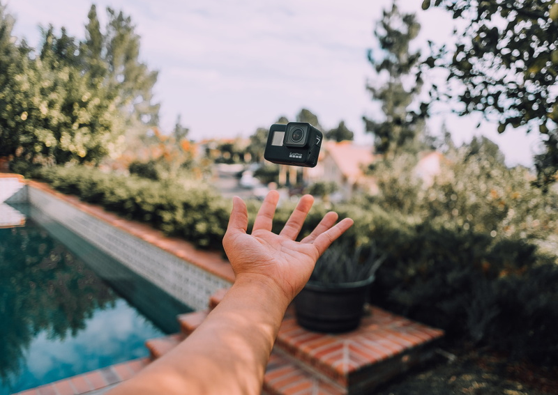 lifestyles, electronics, plant, california, muted, pool, one person, camera, real people, finger, human finger, travel, action, selective focus, tree, personal perspective