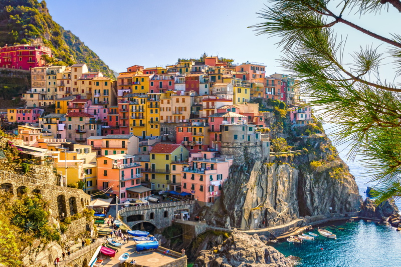 nautical vessel, travel, canal, building, water, hills, summer, day, mountain, village, city, waterfront, clear sky, houses, vacations, architecture, no people
