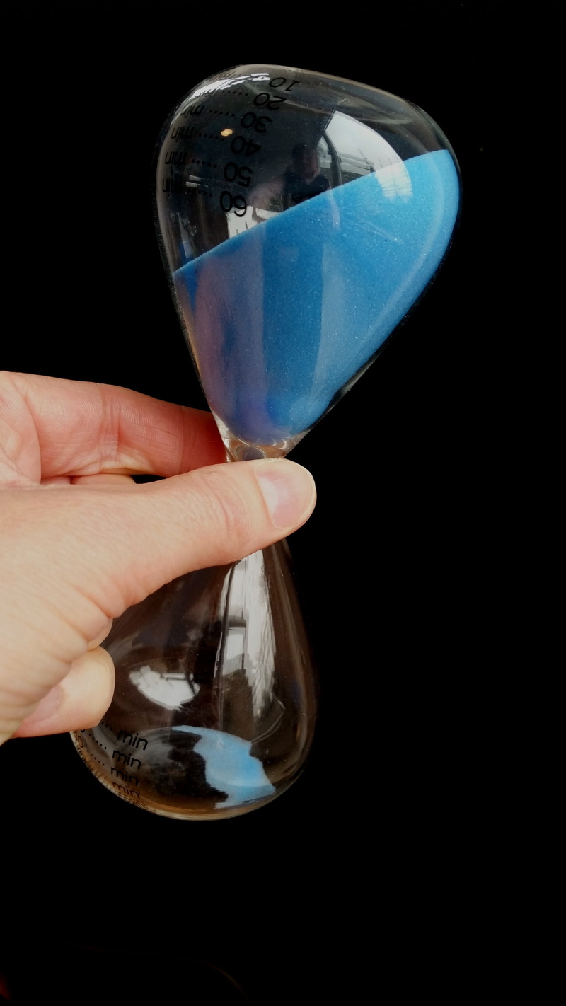 interval, timepiece, hourglass, food and drink, refreshment, real people, body part, glass, people, blue, minutes, one person, sand, silhouette, tempus