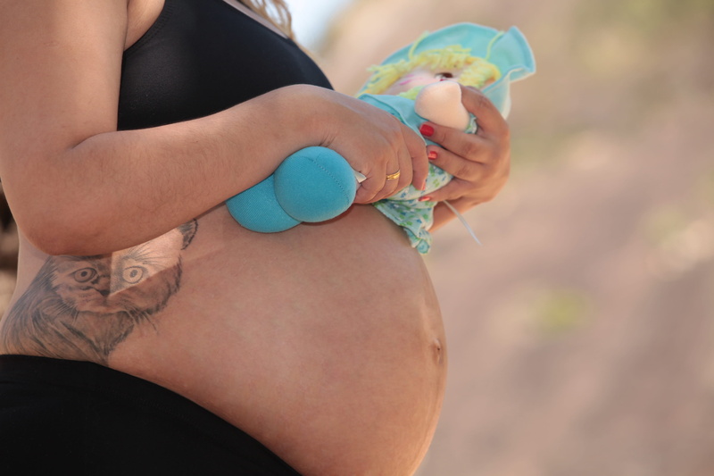 holding, midsection, hand, baby, real people, limb, close-up, mother, future mother, human body part, pregnant book, human hand, one person, body part