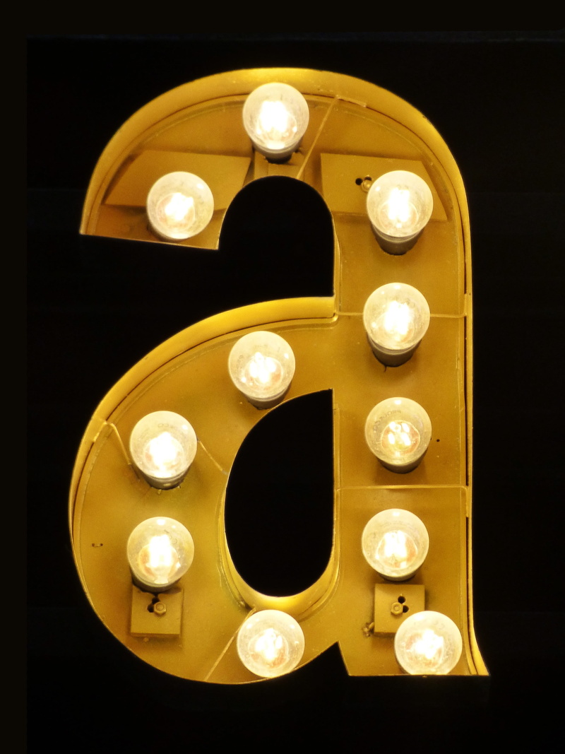 music, gold colored, electricity, light bulbs, antique, studio shot, letter a, vanity, geometric shape, glowing, old-fashioned, dark, illuminated, directly below