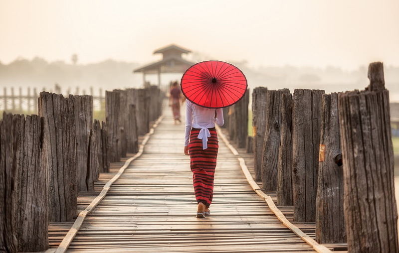 red, built structure, robe, portrait, religion, full length, umbrella, footbridge, walking, bridge, Thailand, women, Asian, one person, adult, child, wood - material