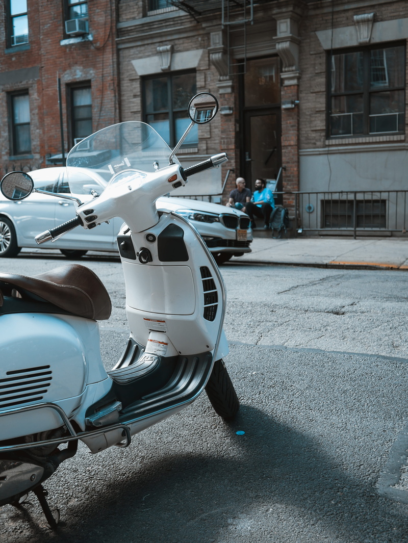 motorcycle, street, parked, day, motor scooter, outdoors, scooter, village, motor vehicle, stationary, road, van, automobile, city, gray, building exterior