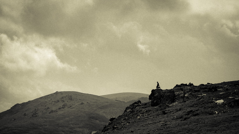 grass, activity, black and white, mountain peak, on edge, scenery, rock, environment, standing, sepia, real people, rock - object, precipice, nature, one person