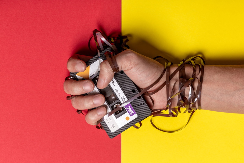 power supply, studio shot, human body part, close-up, music, hand, yellow, connection, tape, cable, indoors, colored background, cassette, finger, communication