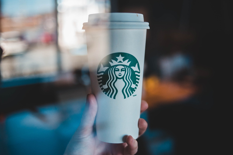 real people, mug, human body part, holding, unrecognizable person, cup, coffee cup, symbol, alcohol, finger, human hand, coffee, starbucks, computer, logo