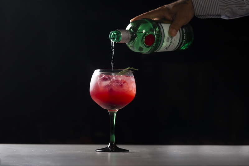hand, black background, fruit, food and drink, strawberry drink, juice, holding, electronics, indoors, goblet, healthy eating, human body part, human, camera