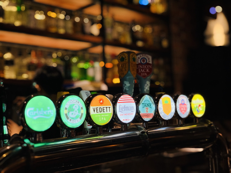 still life, drink, beer, pub, in a row, text, focus on foreground, variation, glass, alcohol, bottle, human, shelf, night, container, choice, liquor, multi colored