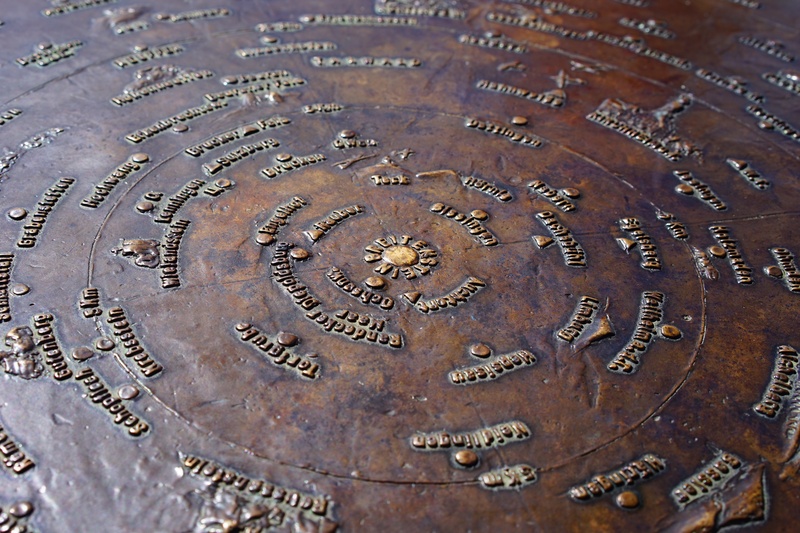 bronze crafts, shape, bronze, wet, compass point, location specified, backgrounds, distance scale, outdoors, water, no people, circular, distance blackboard