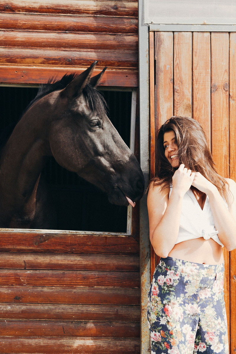 Gabriella Maia, portrait display, horse, livestock, bare shoulders, brunette, adult, hair, hairstyle, portrait, one person, blouses, stable, smiling, wooden surface