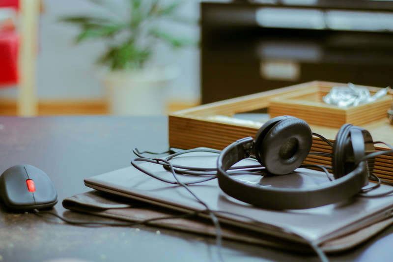 table, no people, glasses, headset, desk, furniture, black, desktop, stack, publication, headphones, work, kitchen utensil, plate, coffee table, metal