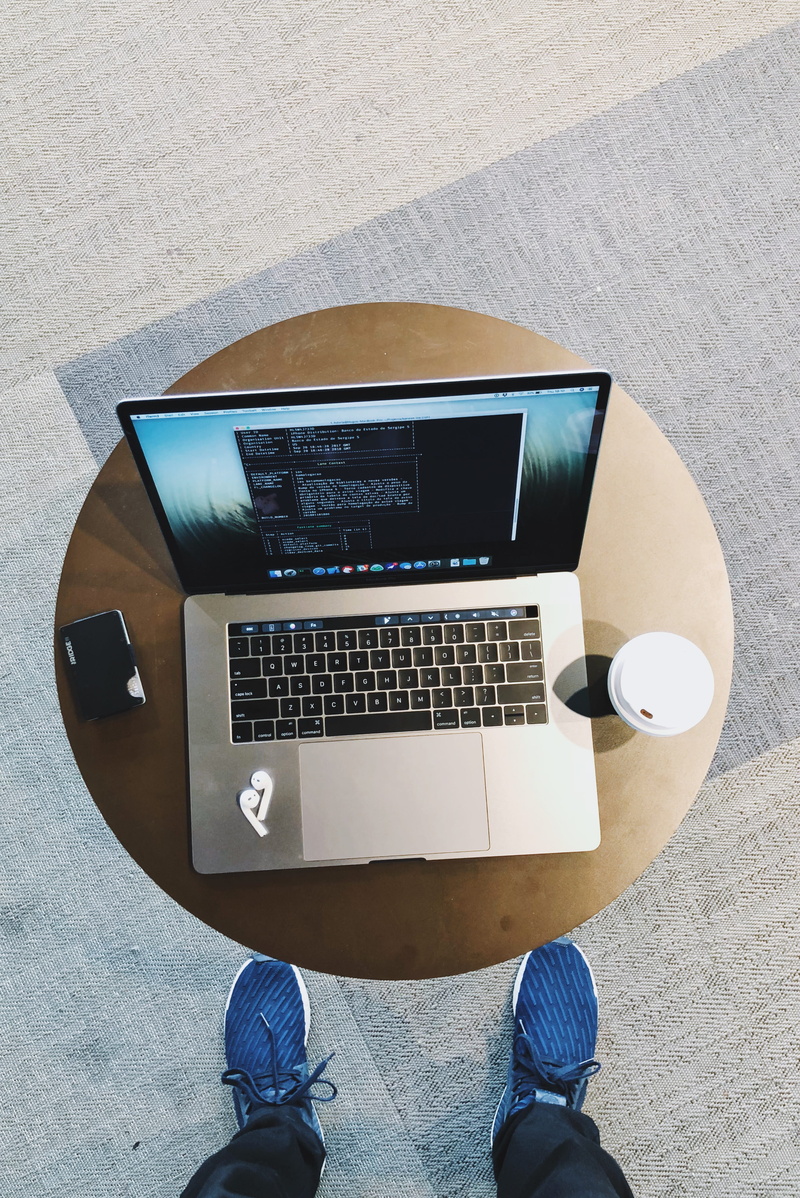low section, using laptop, apple, technology, keyboard, airpods, table, computer equipment, coffee, connection, macbookpro, laptop, human foot, men, standing
