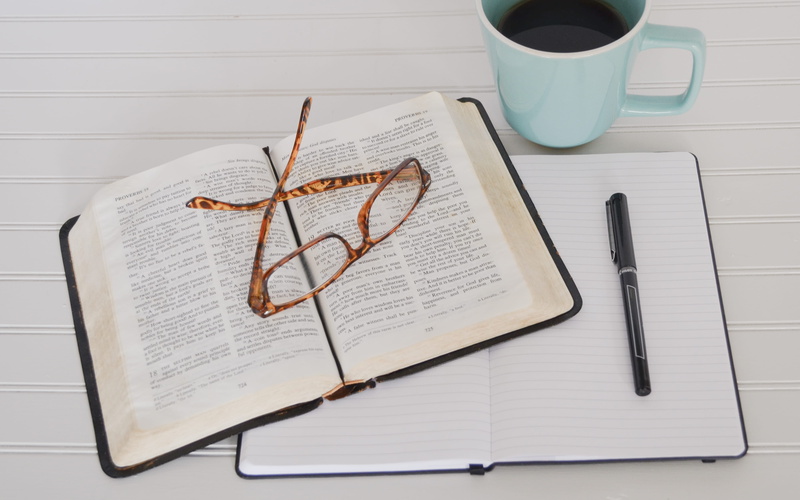 paper, publication, table, note pad, bible, book, high angle view, still life, personal accessory, coffee cup, eyeglasses, mug, indoors, tray, refreshment