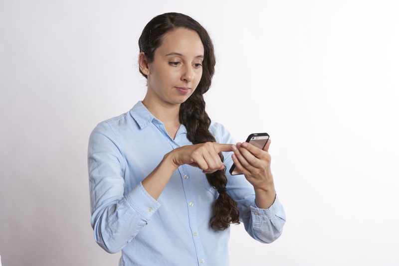 young, woman, pointing, smart phone, person, business, people, communication, women, project management, telephone, job interview, happy, studio shot, reading