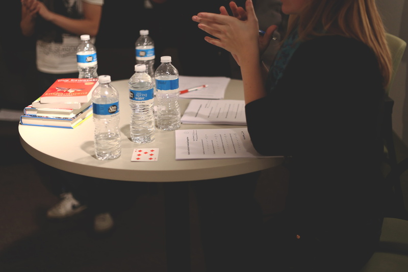 near, chair, ideas, holding, incidental people, education, plastic, discuss, bottle, bottled water, woman, table, woman in black, sitting, lifestyles, adult