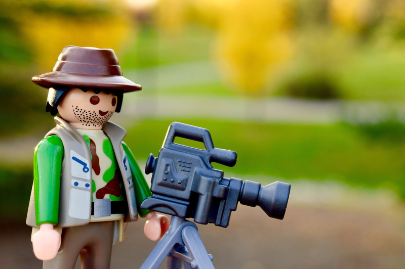 photographer, photographing, focus, outdoors, grass, camera, camera lens, close up, activity, lego, photograph, plant, human representation, focus on foreground