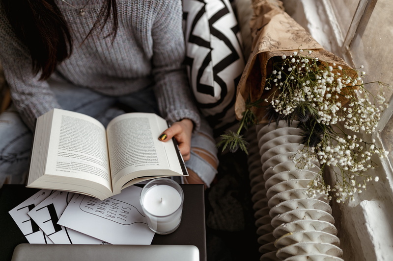 furniture, adult, human body part, female, sitting, cup, book, indoors, coffee - drink, floral pattern, girl, woman, human hand, pullover, table, reads