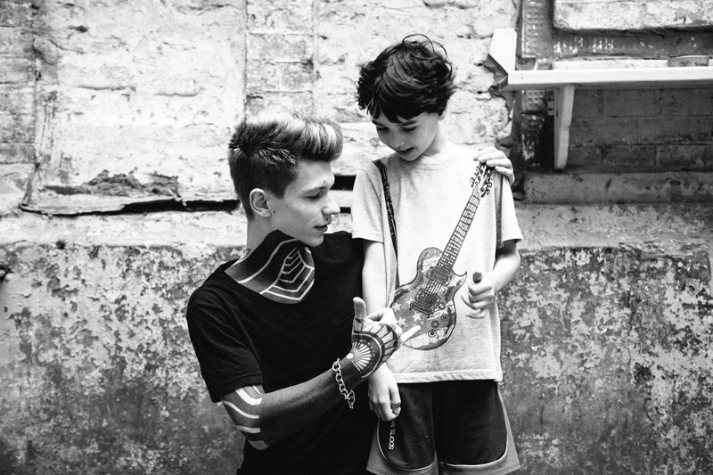 bonding, casual clothing, man, day, child, architecture, man and boy, black and white, guitar, real people, togetherness, standing, grayscale, leisure activity