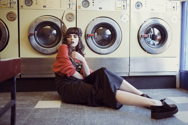 adult, one person, on the floor, leisure activity, appliance, indoors, washing machine, holding, laundromat, sitting, lifestyles, young women, casual clothing