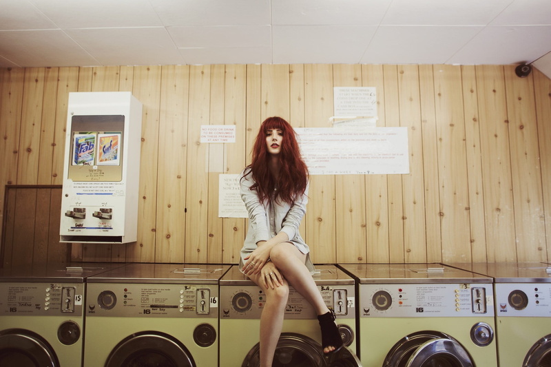 leisure activity, long hair, young adult, one person, adult, sitting, legs, front view, mini dress, laundry, real people, young women, red lipstick, indoors