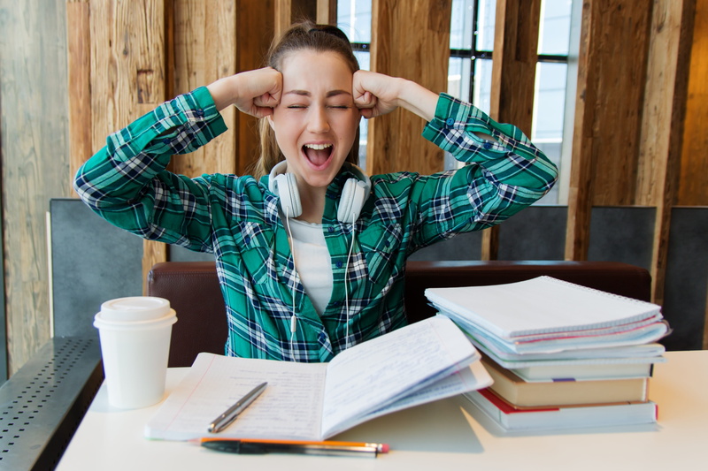 emotional stress, student, indoors, notebook, pen, mouth, girl, casual clothing, college, think, young, real people, table, one person, sitting, education