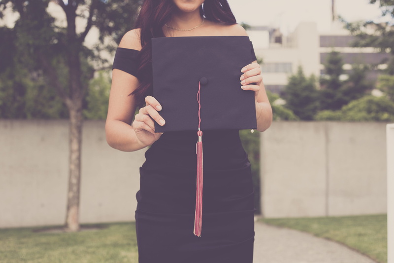 2K, one person, standing, graduation, midsection, child, mba, portable information device, academic, university, cap, holding, women, outdoors, casual clothing