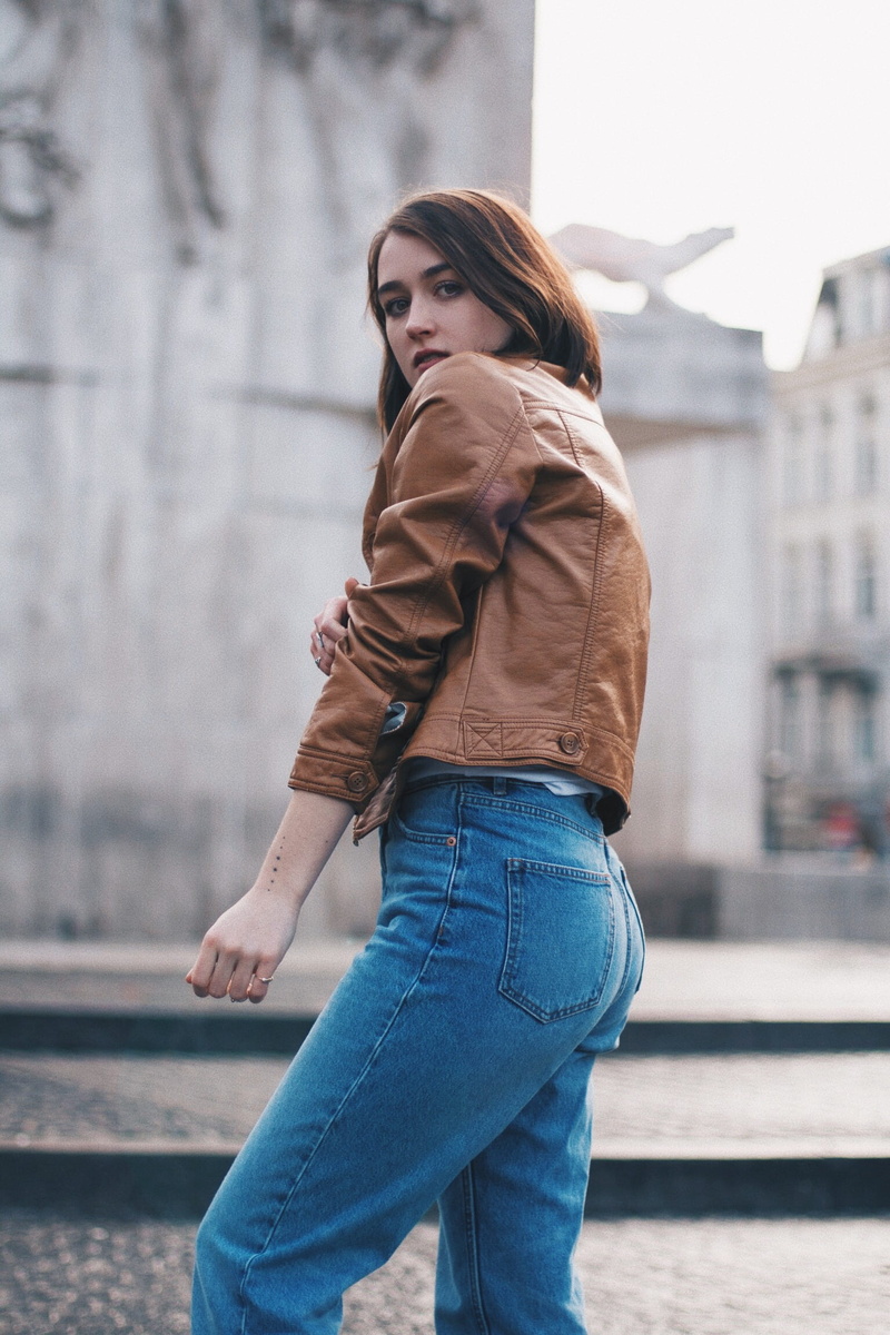 side view, beautiful woman, building, closeup, young adult, jacket, scarf, beauty, brown, stands, real people, urban, lifestyles, built structure, denim