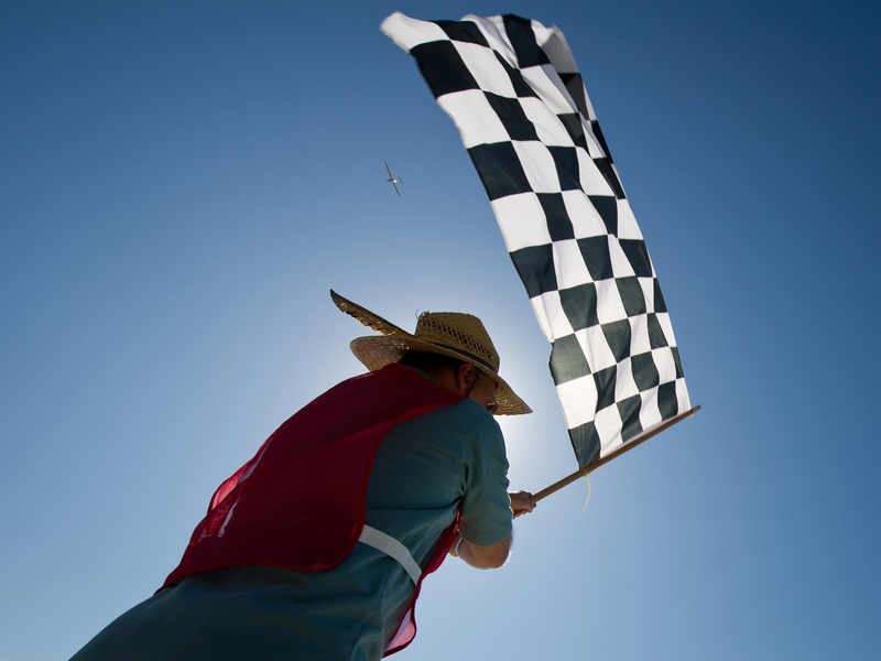 clouds, airplane-race, black, leisure activity, day, copy space, freedom, clear sky, sky, blue, finish, sunlight, lifestyles, man, carrying, flag, outside